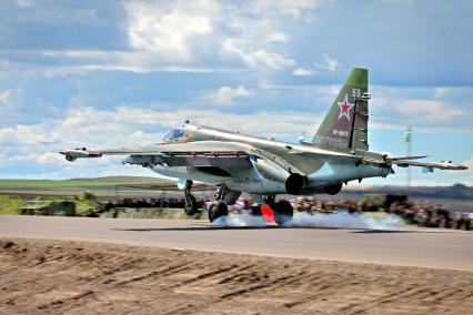 Военный штурмовик Су-25 `Грач` совершает посадку на автомобильную дорогу.