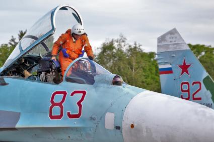 Летчик вылезает из `фонаря` военного самолета Су-35.