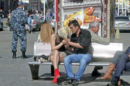 Мужчина прикуривает девушке сигарету.
