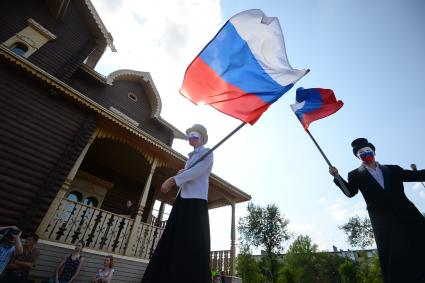 День государственного флага России. Культурный комплекс `Национальная деревня`. На снимке: артисты на ходулях с российскими флагами.