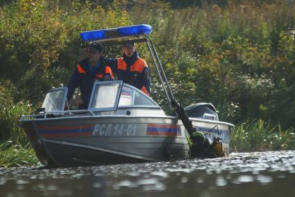 Водолаз держится за борт спасательного катера после поиска взрывчатки у плотины Волчихинского водохранилища. антитеррористические учения