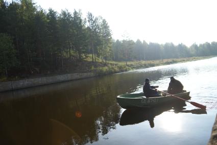 Условные террористы плывут на лодке к плотине Волчихинского водохранилища, во время антитеррористических учений