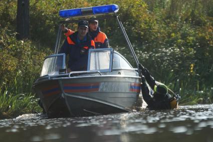 Водолаз держится за борт спасательного катера после поиска взрывчатки у плотины Волчихинского водохранилища. антитеррористические учения