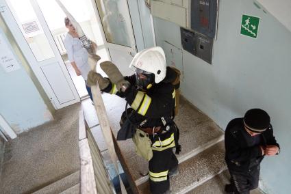 Пожарные протягивают пожарный руков на 3-й этаж больницы для тушения условного пожара. Пожарные учения в ГКБ №23 в Екатеринбурге