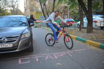 Девушка в автомобиле, мужчина на велосипеде.