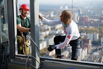 человек-паук Ален Робер (Alain Robert) залезает на смотровую площадку бизнес центра \"Высоцкий\" на 52 этаже в Екатеринбурге