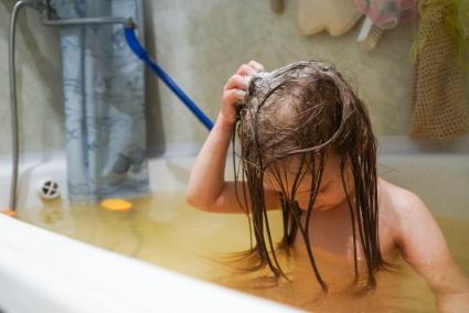 ребенок купается в ванной, в желтоватой воде