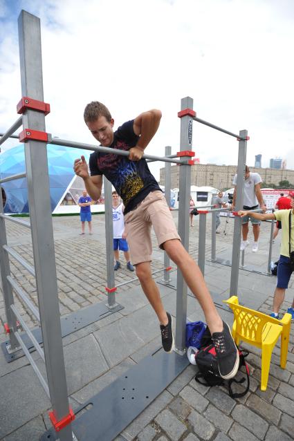10-й физкультурно-спортивный форум `Готов к труду и обороне`. На снимке:  молодой человек подтягивается на турнике.
