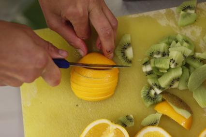 Магазин сети `Вестер`. На снимке: кондитер нарезает апельсин для приготовления пирожных.