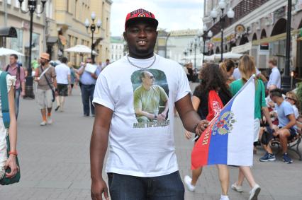 Афроамериканец в футболке с изображением В. Путина и с  флагом РФ