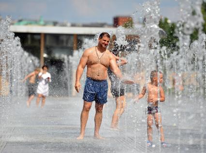 Жара в Москве. На снимке: мужчина и мальчик в фонтане