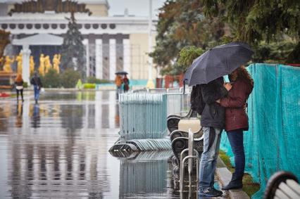 Мужчина и женщина под зонтом.