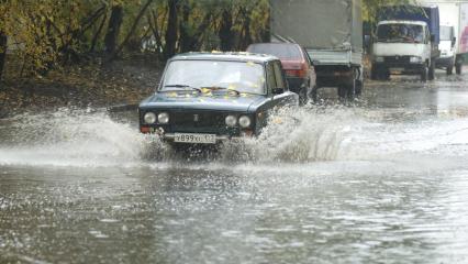 Автомобиль `Жигули` едет по лужам.