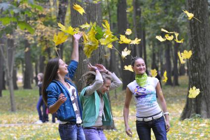 Осенний парк. На снимке: девушки кидают листья.