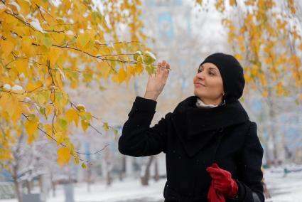 Девушка фотографируется с желтыми листьями на дереве