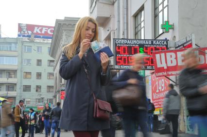 Девушка с деньгами около операционной кассы у м. `Белорусская`.