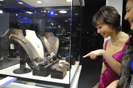 Выставка самых дорогих товаров `Ярмарка миллионеров` Millionaire Fair -2008`. На снимке: девушка смотрит на витрину с ювелирными украшениями.