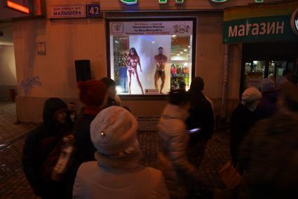 Бодибилдер и фитнес-девушка в витрине, во время акции \"Живые манекены\" в спортивном магазине Екатеринбурга