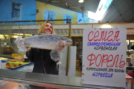 Рыбный отдел в магазине. На снимке: девушка выбирает норвежскую семгу.