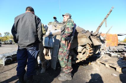 Одна из ремонтных баз Донецкой народной республики (ДНР), где пленные помогают ремонтировать военную технику, подбитую и брошенную украинскими войсками. На снимке: ополченец с позывным Крокодил (справа).