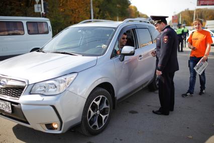 Совместная акция `Комсомольской правды` и ГИБДД `Улыбнись и пристегнись`. На снимке: начальник УГИБДД ГУ МВД России по Ставропольскому краю подполковник полиции Алексей Сафонов разговаривает с водителем.