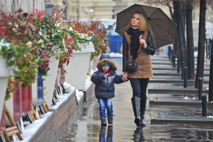 Первый снег в Москве. На снимке: женщина с ребенком идут по улице.