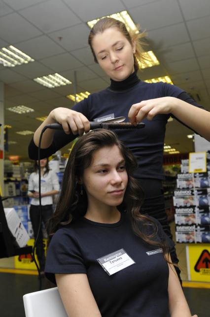 Магазин бытовой техники `Техносила`. На снимке: сотрудницы магазины демонстрируют плойку для волос.
