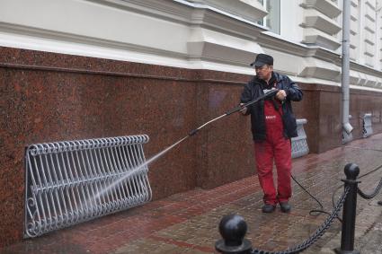 Гастарбайтер моет здание.