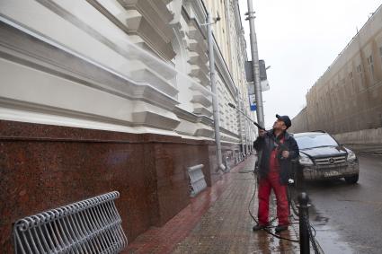 Гастарбайтер моет здание.