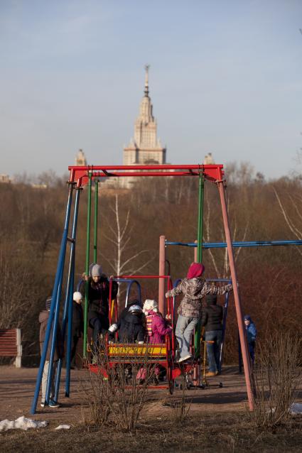 Дети гуляют на площадке в парке.