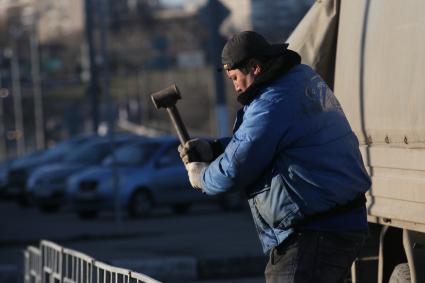 Гастарбайтер бьет молотком по ограждению