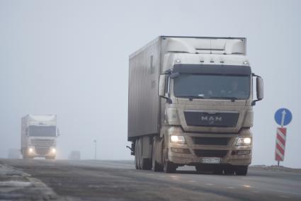 Грузовые автомобили на трассе во время тумана