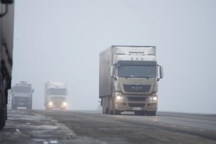 Грузовые автомобили на трассе во время тумана