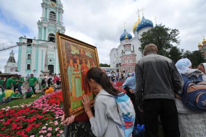 Мероприятия к 700-летию со дня рождения Преподобного Сергия Радонежского. Троице-Сергиева Лавра. На снимке: девушка у иконы Святых Страстотерпцев Романовых.