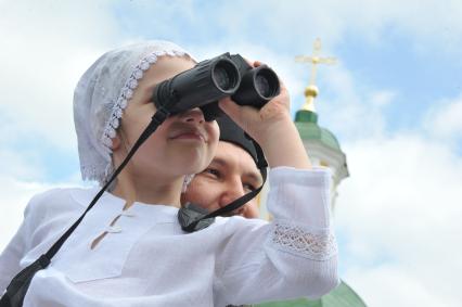 Мероприятия к 700-летию со дня рождения Преподобного Сергия Радонежского. На снимке: девочка с биноклем и служитель церкви.