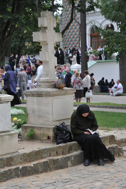 Мероприятия к 700-летию со дня рождения Преподобного Сергия Радонежского. Троице-Сергиева Лавра. На снимке: женщина у могилы Архимандрита Афанасия - Наместника Троице-Сергиевой Лавры.