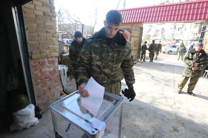 Донецкий аэропорт. Выборы главы ДНР. На снимке: ополченец с позывным Гиви отправляет бюллетень в урну для голосования.