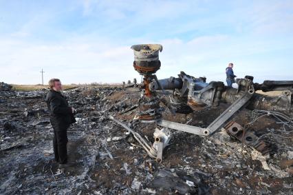 Место крушения малайзийского самолета Boeing, выполнявшего рейс MH17 Амстердам — Куала-Лумпур. На снимке: специальный корреспондент Николай Варсегов и осматривает обломки самолета.