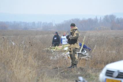 Место крушения малайзийского самолета Boeing, выполнявшего рейс MH17 Амстердам - Куала-Лумпур. На снимке: голландские эксперты и представители ОБСЕ работают на месте крушения.