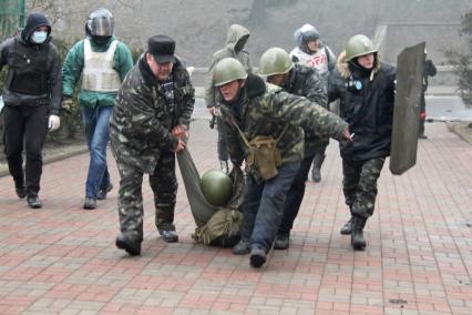 Беспорядки в Киеве. Представители оппозиции волокут раненого митингующего.