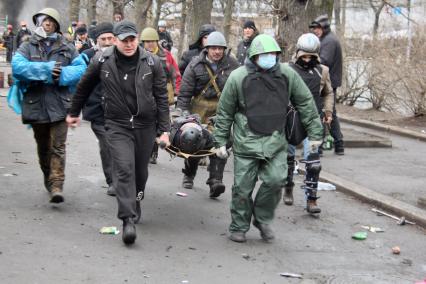 Беспорядки в Киеве. Представители оппозиции несут раненого митингующего.