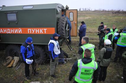 Погрузка обломков потерпевшего крушение малайзийского самолета Boeing-777, выполнявшего рейс MH17 Амстердам - Куала-Лумпур. На снимке: следователи из Нидерландов во время сбора обломков.