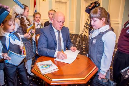 Губернатор Омской области Виктор Назаров ставит свою подпись в дневнике девочки. Набравшие больше всего хороших оценок в своей возрастной категории дети приглашены на `урок` к губернатору.