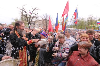 Ситуация в Луганске. На снимке: батюшка окропляет святой водой местных жителей во время Крестного хода. Люди направляются к зданию Службы безопасности Украины (СБУ) на митинг, где по завершению состоится народное голосование.