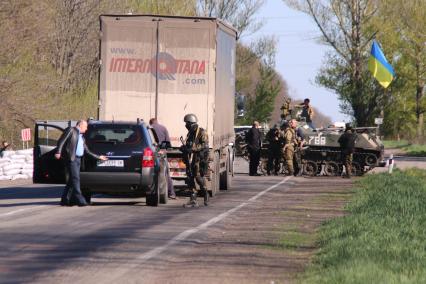 Под Славянском. Блок-пост украинский военных `Малиновка`. На снимке: военный досматривает багажник машины.