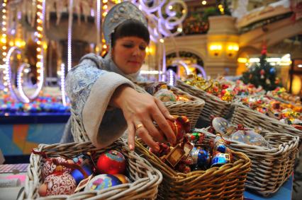 Ярмарка елочных игрушек в ГУМе. На снимке: девушка в костюме Снегурочки выбирает елочные шары.