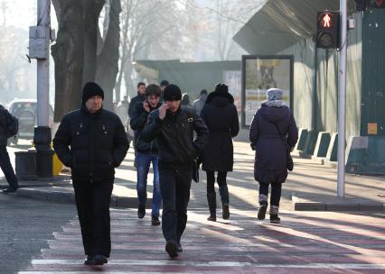 Пешеходы увлеклись разговорами по телефону и нарушают ПДД переходя проезжую часть на красный сигнал светофора