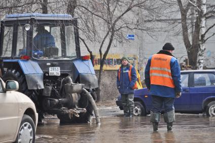 Сотрудники водоканала на затопленной из-за аварии дороге во дворе жилого дома