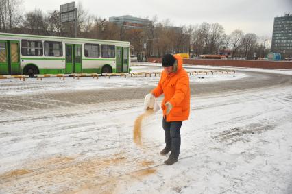 Экспертиза `КП`: Чем посыпают столичные дороги. На снимке:  корреспондент `КП` Олег Адамович посыпает дорогу  песком.