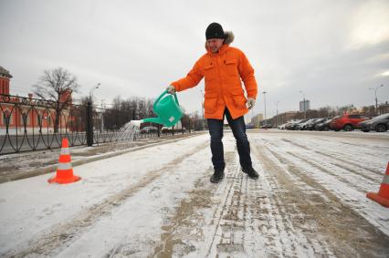 Экспертиза `КП`: Чем посыпают столичные дороги. На снимке:  корреспондент `КП` Олег Адамович поливает из  садовой лейки жидкими реагентами скользкую дорогу.